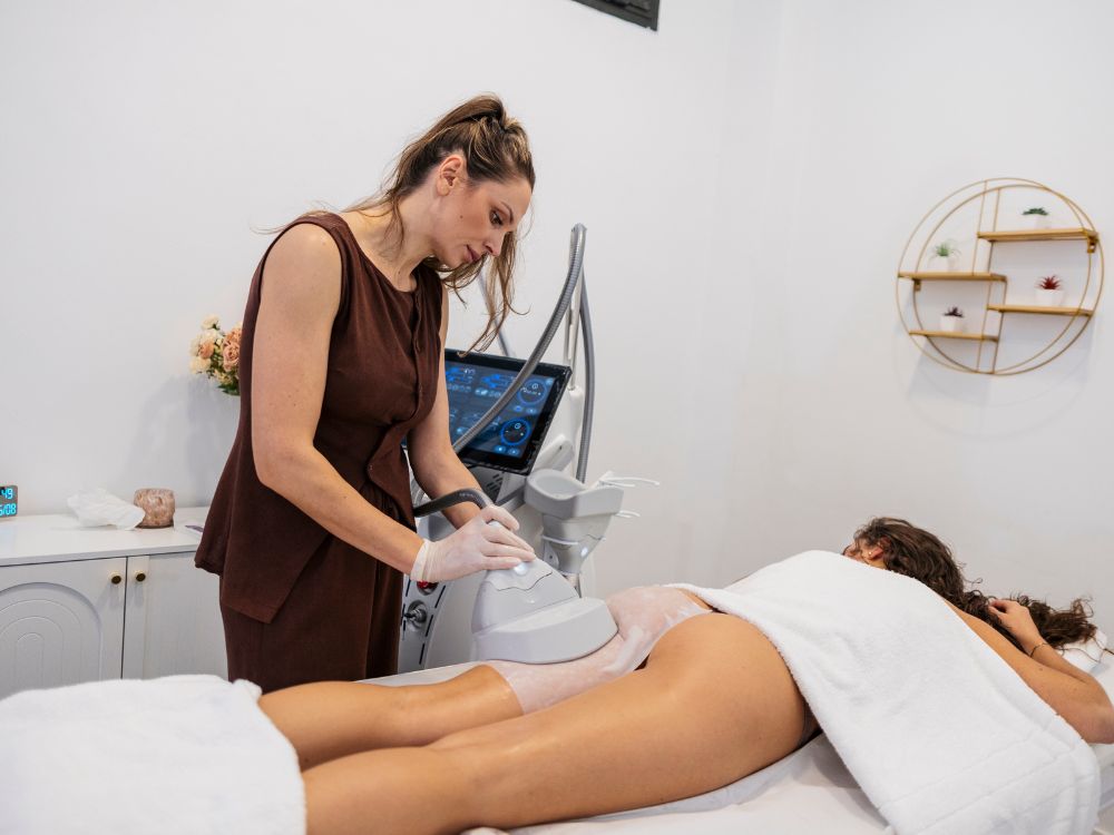 Profissional realizando procedimento estético com aparelho em paciente, mostrando como funciona a lipo sem corte na redução de medidas.