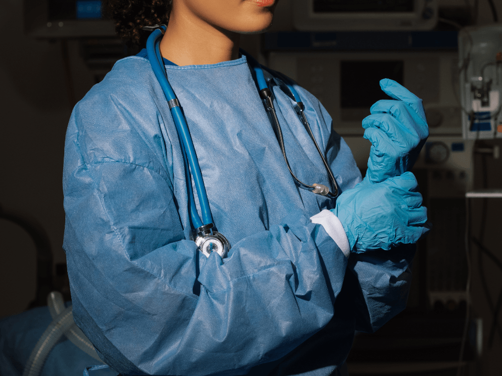 Profissional de saúde veste luvas e equipamentos de proteção durante preparação para abdominoplastia acima do peso