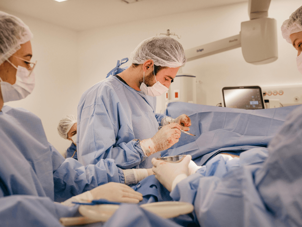 Equipe médica realizando cirurgia em centro cirúrgico e demonstrando se em mastopexia usa dreno.