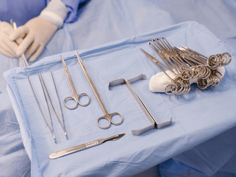 Instrumentos cirúrgicos esterilizados organizados sobre mesa operatória, utilizados durante o procedimento e para explicar como é feito abdominoplastia.