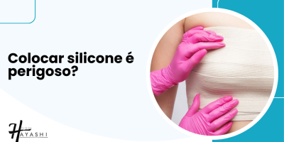 Paciente em avaliação pós-cirúrgica com faixa compressiva enquanto profissional analisa a região das mamas para esclarecer se colocar silicone é perigoso.