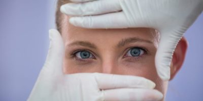 doctor-examining-female-patients-face-from-cosmetic-treatment